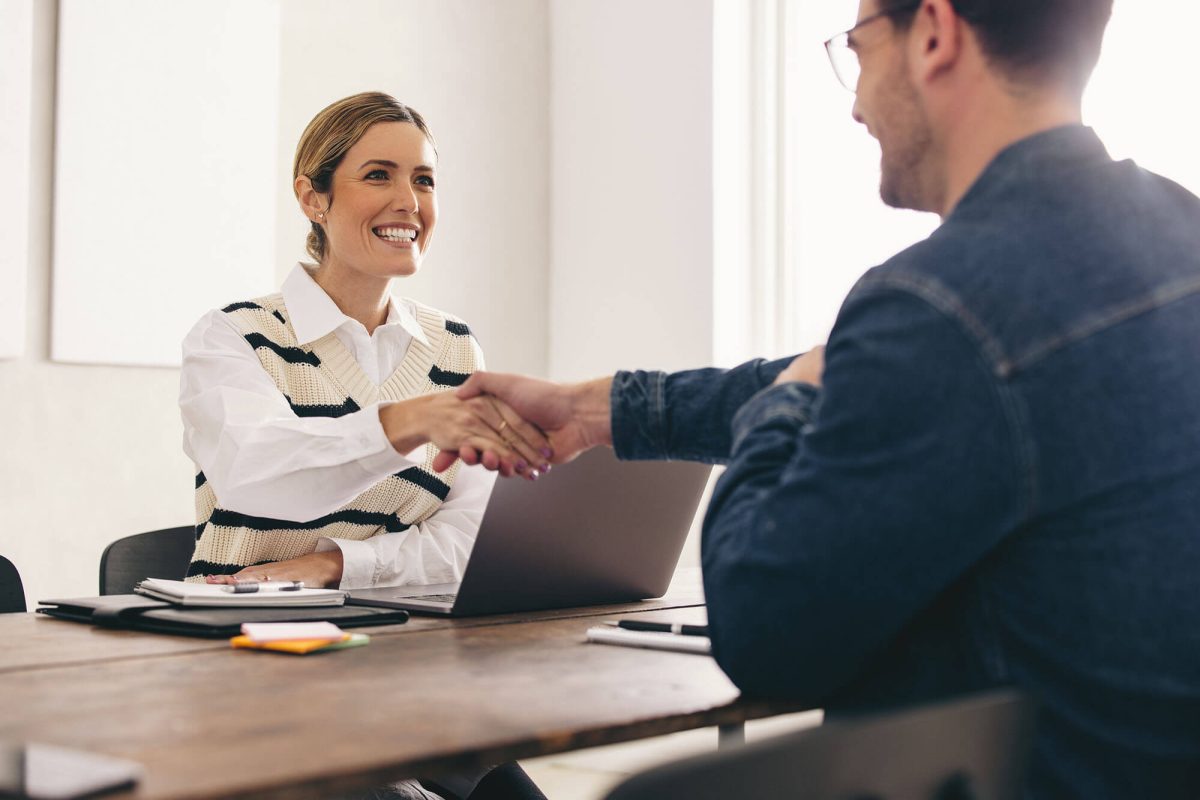 Woman smiling while shaking a client's hand